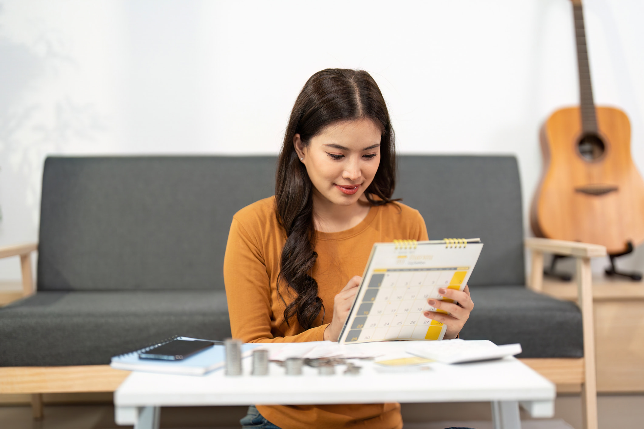 Person in yellow sweater reviewing paycheck