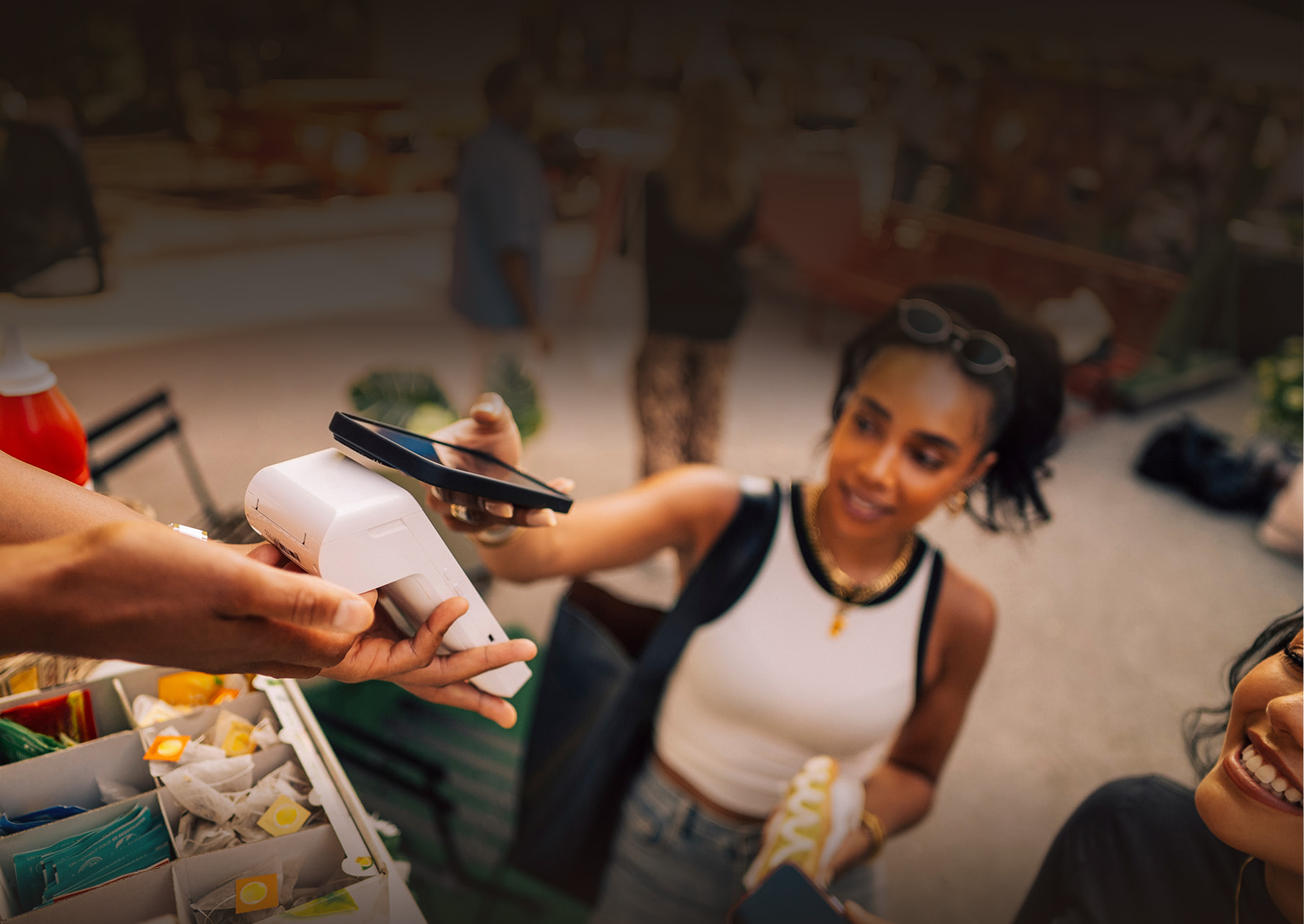 A young woman purchasing a hotdog by paying with her phone