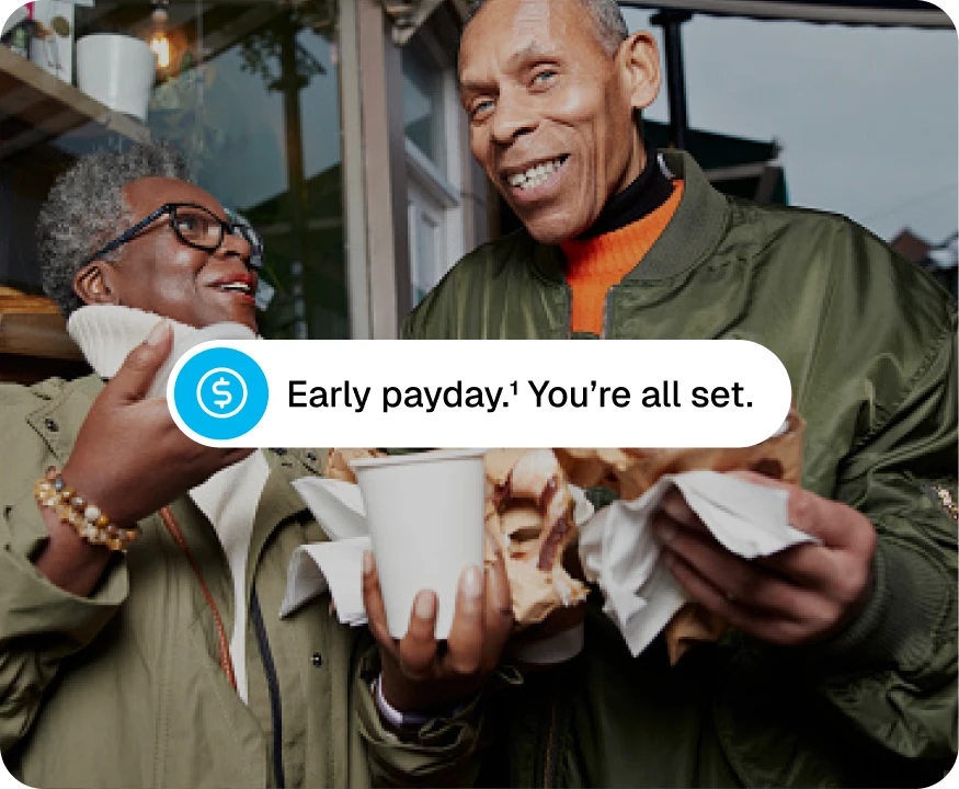 A man and woman carrying backed goods with a notification saying "Early payday. You're all set."